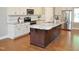 Modern kitchen boasts white cabinetry, stainless appliances, and granite countertops, complemented by hardwood flooring at 120 Glen Oaks Dr, Youngsville, NC 27596