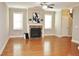 Bright living room with hardwood floors, a cozy fireplace, and abundant natural light from large windows overlooking the backyard at 120 Glen Oaks Dr, Youngsville, NC 27596
