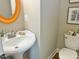 Charming half bath featuring a pedestal sink and decorative mirror at 120 Glen Oaks Dr, Youngsville, NC 27596