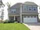 Charming two-story home with a well-manicured lawn, stone accents, and an attached two-car garage at 124 Richmond Run, Stem, NC 27581