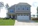 Charming two-story home with a well-manicured lawn, stone accents, and an attached two-car garage at 124 Richmond Run, Stem, NC 27581