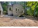 View of home's exterior featuring multiple windows and stairway in wooded lot at 127 Creekwood, Pittsboro, NC 27312