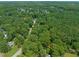 An aerial view of a wooded property with homes nestled among the green trees at 1317 Elmset Ln, Durham, NC 27713