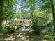 Large backyard with a patio, fire pit, seating area, and mature trees at 1317 Elmset Ln, Durham, NC 27713