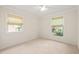 Bright, carpeted bedroom with natural light from two windows and ceiling fan at 1317 Elmset Ln, Durham, NC 27713