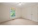 Inviting bedroom with plush carpet, a window with a view, and a double door closet at 1317 Elmset Ln, Durham, NC 27713