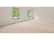 Bright bedroom with two windows, neutral walls, and plush carpeting that creates a cozy atmosphere at 1317 Elmset Ln, Durham, NC 27713