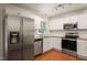 Well-lit kitchen featuring stainless steel appliances, granite countertops, and white cabinets at 1317 Elmset Ln, Durham, NC 27713