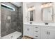 Modern bathroom featuring a double vanity and stylish tiled shower with a stone floor at 157 Cherrybirch Ln, Zebulon, NC 27597