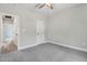 Bedroom with neutral walls, carpeted floors, ceiling fan, and white paneled door leading to hallway at 157 Cherrybirch Ln, Zebulon, NC 27597