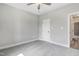 Bedroom with neutral walls, carpeted floors, ceiling fan, and white paneled door leading to bathroom at 157 Cherrybirch Ln, Zebulon, NC 27597