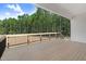 Wooden deck with black metal railing offering a view of surrounding woods at 157 Cherrybirch Ln, Zebulon, NC 27597