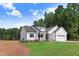 Stylish home showcasing a well-kept lawn, white vertical siding, and a matching attached garage at 157 Cherrybirch Ln, Zebulon, NC 27597