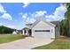 Charming home with an attached garage, well-manicured lawn, and plenty of parking on the concrete driveway at 157 Cherrybirch Ln, Zebulon, NC 27597