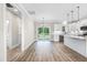 Kitchen view from the dining area with white cabinets, hardwood flooring, and stainless steel appliances at 157 Cherrybirch Ln, Zebulon, NC 27597