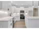 Well-lit kitchen showcasing sleek white cabinets, stainless steel appliances, and modern fixtures at 157 Cherrybirch Ln, Zebulon, NC 27597