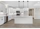Bright, well-lit kitchen featuring white cabinets, an island with pendant lighting, and modern appliances at 157 Cherrybirch Ln, Zebulon, NC 27597