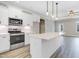 Bright kitchen featuring white cabinets, stainless appliances, and an island with quartz countertops at 157 Cherrybirch Ln, Zebulon, NC 27597