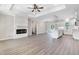 Open-concept living space featuring hardwood floors, a fireplace, and a view of the modern kitchen at 157 Cherrybirch Ln, Zebulon, NC 27597