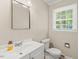 Simple bathroom with white vanity, toilet, and natural light from window at 1704 Little John Ct, Burlington, NC 27217