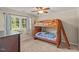Bright bedroom featuring a wooden bunk bed, side table, and two windows with sheer curtains at 1704 Little John Ct, Burlington, NC 27217