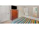 Comfortable bedroom featuring a colorful bedspread, television and neutral walls with a view to the bathroom at 1704 Little John Ct, Burlington, NC 27217