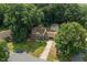 Traditional two-story home featuring a lush, green lawn, mature trees, and a detached garage at 1704 Little John Ct, Burlington, NC 27217