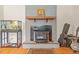 Charming living room featuring a brick fireplace, guitars, an aquarium and decorative mantel at 1704 Little John Ct, Burlington, NC 27217