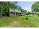 A yellow and brick two-story home with a covered front porch and a green lawn at 1704 Little John Ct, Burlington, NC 27217