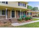 A charming front porch with brick accents, blue chairs, and a well-manicured garden at 1704 Little John Ct, Burlington, NC 27217
