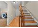 Hallway with hardwood floors, white trim, and a staircase with wood railings at 1704 Little John Ct, Burlington, NC 27217