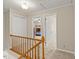Bright hallway with carpet and wooden railing, leading to bedrooms with ample natural light at 1704 Little John Ct, Burlington, NC 27217
