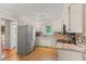 Bright kitchen with white cabinets, stainless steel appliances, and a mosaic backsplash at 1704 Little John Ct, Burlington, NC 27217