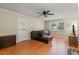 Cozy living room with hardwood floors, leather sofa, ceiling fan, and natural light at 1704 Little John Ct, Burlington, NC 27217