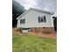 Side view of home featuring gray siding, dark shutters, and brick foundation at 175 Ann Dr, Timberlake, NC 27583
