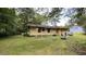 View of the backyard with home, partial bench, and a wooded tree line at 181 Mangums Dr, Wendell, NC 27591