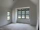 Well-lit bedroom showcasing a high ceiling and large windows overlooking the yard at 200 Meadow Walk Dr, Fuquay Varina, NC 27526