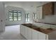 Bright kitchen under construction boasting white cabinets, black-framed windows, and stylish range hood at 200 Meadow Walk Dr, Fuquay Varina, NC 27526