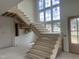 Elegant staircase under construction with large window letting in natural light at 200 Meadow Walk Dr, Fuquay Varina, NC 27526