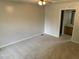 A bedroom with neutral carpeting, a ceiling fan, and an adjacent bathroom at 2012 Ranch Mill Cir, Raleigh, NC 27610