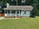 Charming home boasts a welcoming porch and well-manicured lawn, perfect for relaxing outdoors at 2012 Ranch Mill Cir, Raleigh, NC 27610