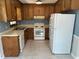 A functional kitchen with wood cabinets, tile floor, and white appliances at 2012 Ranch Mill Cir, Raleigh, NC 27610