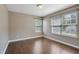 Bright bedroom features two windows with sunlight, hardwood flooring and neutral paint at 211 Cloverdale Dr, Durham, NC 27703