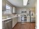 Galley kitchen features stainless steel appliances, gray cabinets, and white countertops at 211 Cloverdale Dr, Durham, NC 27703
