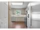 Well-lit kitchen with stainless steel appliances, gray cabinets, and hardwood floors at 211 Cloverdale Dr, Durham, NC 27703