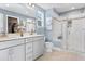 Modern bathroom featuring double sinks, white cabinets, framed mirrors, and glass-enclosed shower at 219 Faith Avenue, Sanford, NC 27330