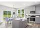 Modern kitchen with stainless steel appliances, large island with sink, and open access to dining area at 219 Faith Avenue, Sanford, NC 27330