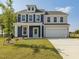 Charming two-story home features a well-manicured lawn and a two-car garage at 227 Faith Avenue, Sanford, NC 27330