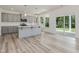 Open kitchen and dining area boasts a center island, stainless appliances, and sliding glass doors to the backyard at 227 Faith Avenue, Sanford, NC 27330