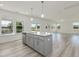 Open kitchen with gray cabinets, stainless steel appliances, and a quartz countertop island at 227 Faith Avenue, Sanford, NC 27330